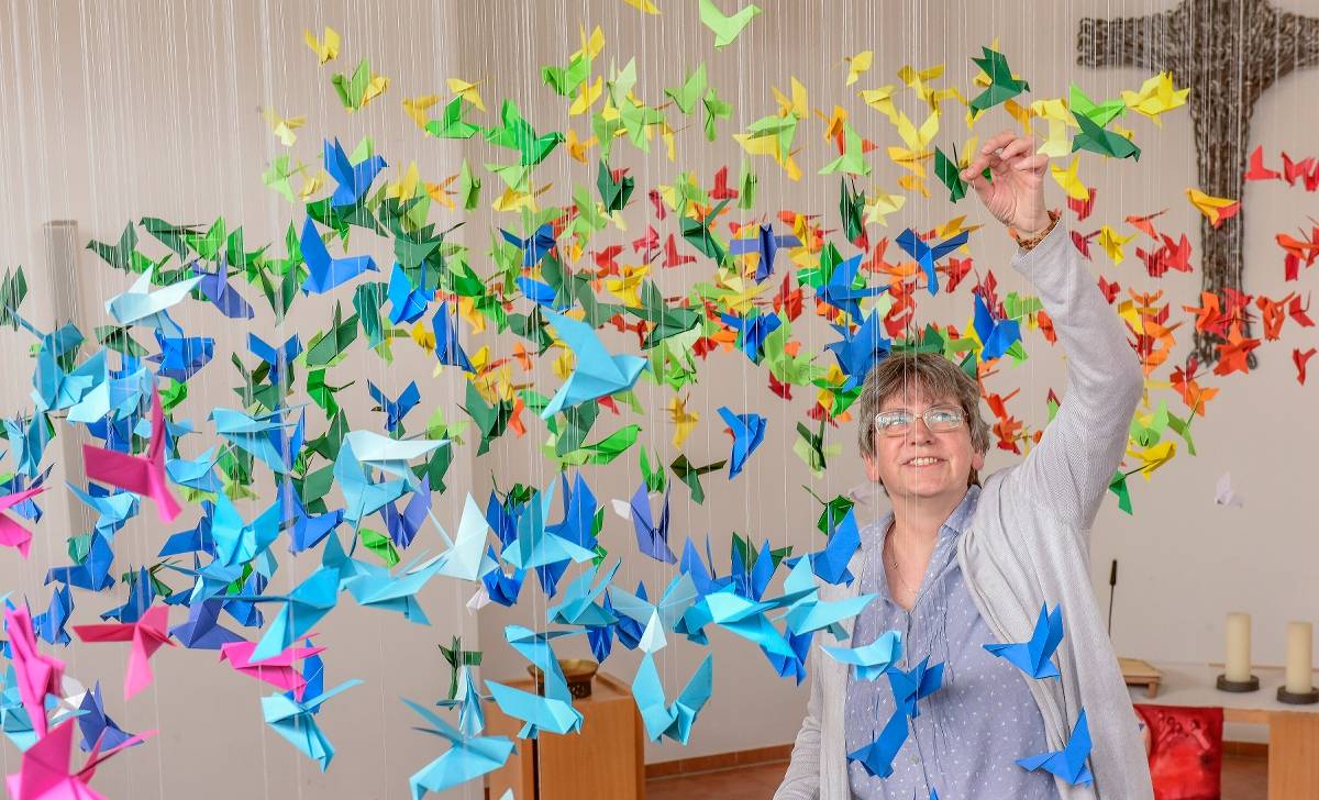  Holger Pykas Installation umfasst Hunderte bunte Tauben aus Papier. Gemeindehelferin Maria Schmoll hängte sie auf. 