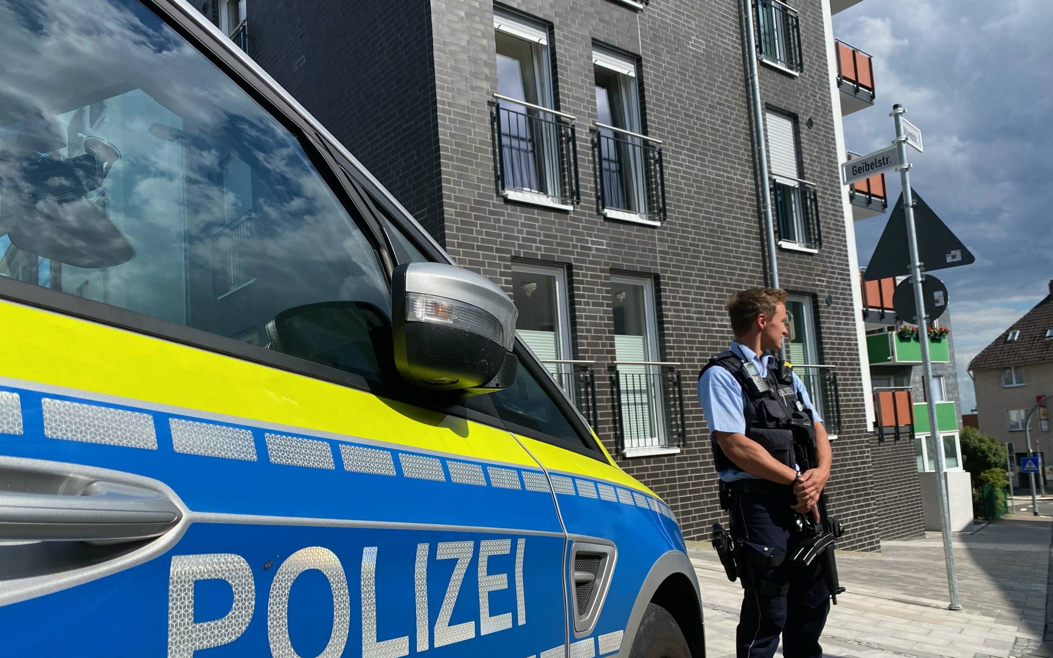  Ein bewaffneter Polizeibeamter steht am Mittwoch in der Nähe eines Wohnhauses in Remscheid. 